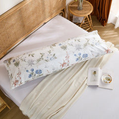 Overhead shot of the long cotton body pillowcase, featuring the detailed blue watercolor floral print on the bed.