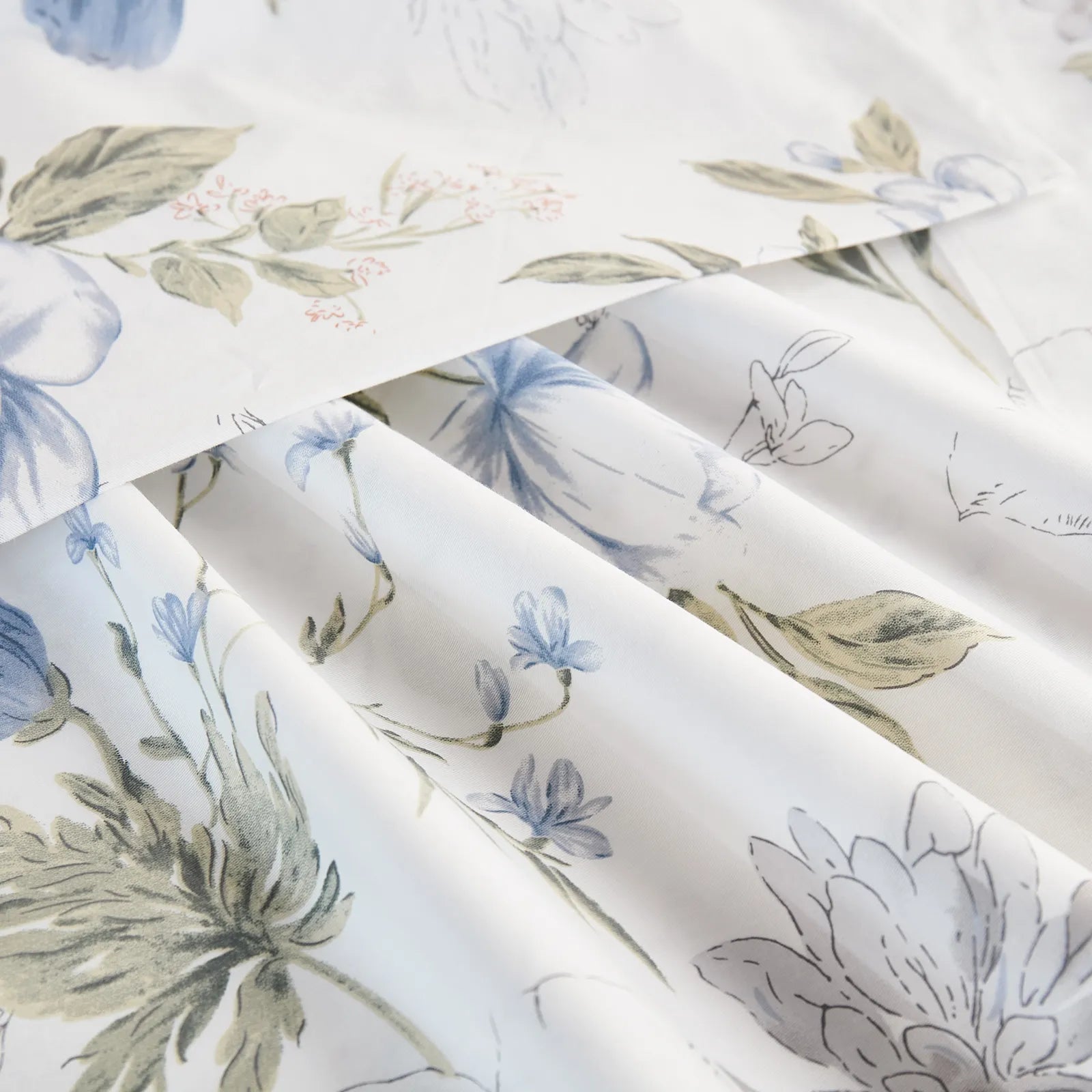 Extreme close-up of the cotton fabric, showing the fine texture and the detailed blue watercolor floral and sketch pattern.