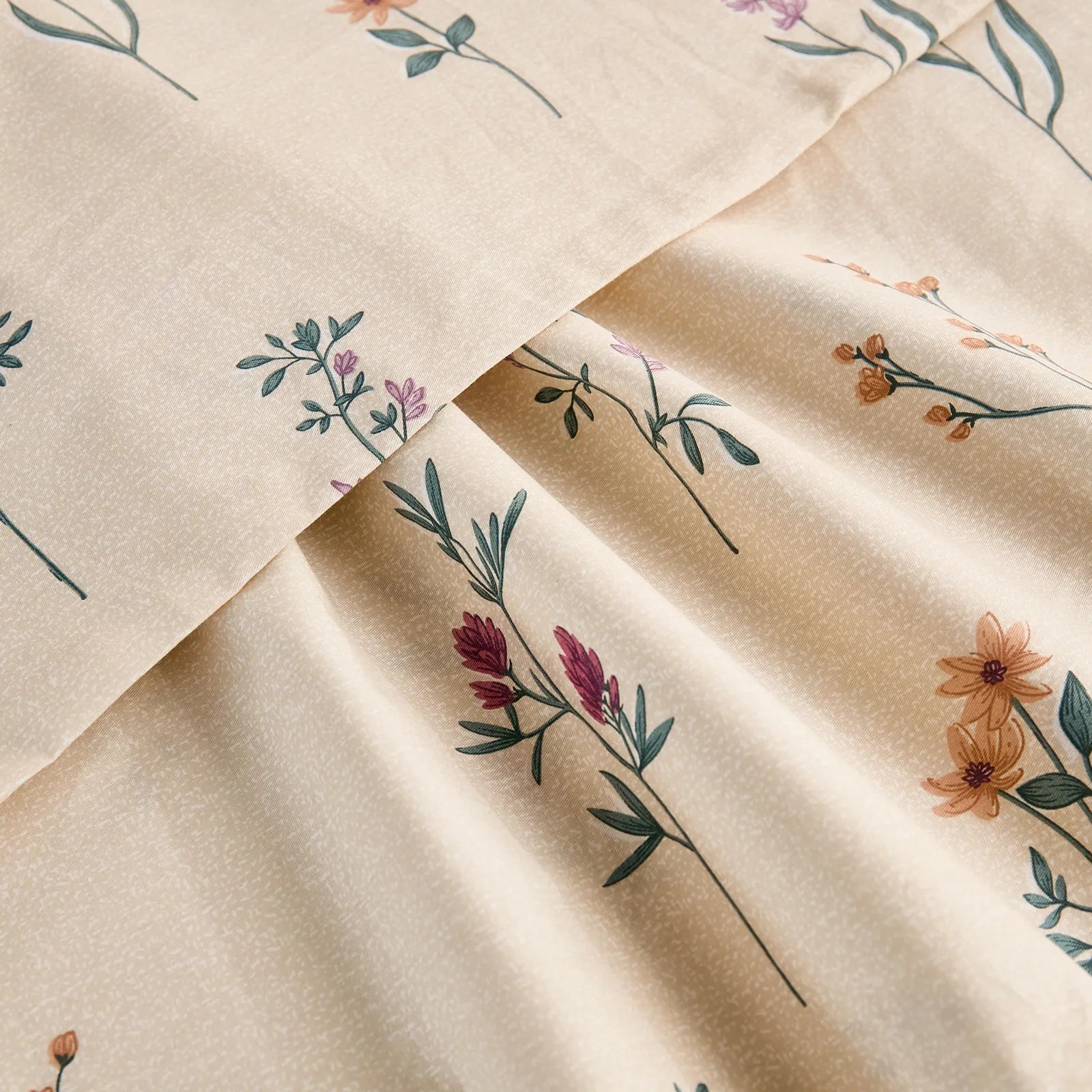 Extreme close-up of the cotton fabric, showing the fine texture and the detailed, multi-colored wildflower pattern.