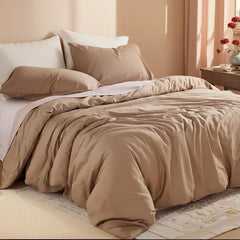 Beige camel duvet cover with corner lifted to reveal purple sheet, books on wooden table.