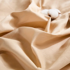 Close-up of beige duvet fabric with one white cotton clusters