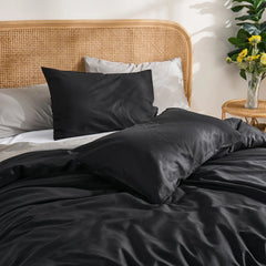 Headboard detail shot of black duvet with brown curtains background, yellow flowers adding color accent.