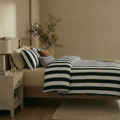 Side view of black white striped duvet and pillows