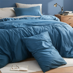 Close-up of blue duvet at headboard with white and blue pillows
