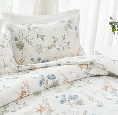 detailed view of the blue floral pillowcases on a bed with striped bedding