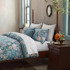Close up of blue peony pattern bedding with white pillows
