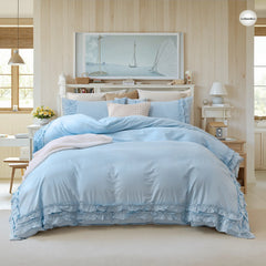 full view of the blue ruffled comforter set styled on a bed.