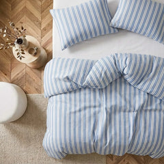 Overhead flat lay of blue white grey striped duvet and cases