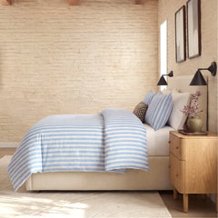 Side view of blue white grey striped duvet and pillows