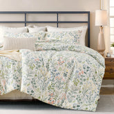 Vintage green floral cotton duvet cover on bed with geometric metal headboard and plant