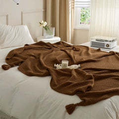 Brown Knitted Throw Blanket on Bed with Candle and Decorative Tray