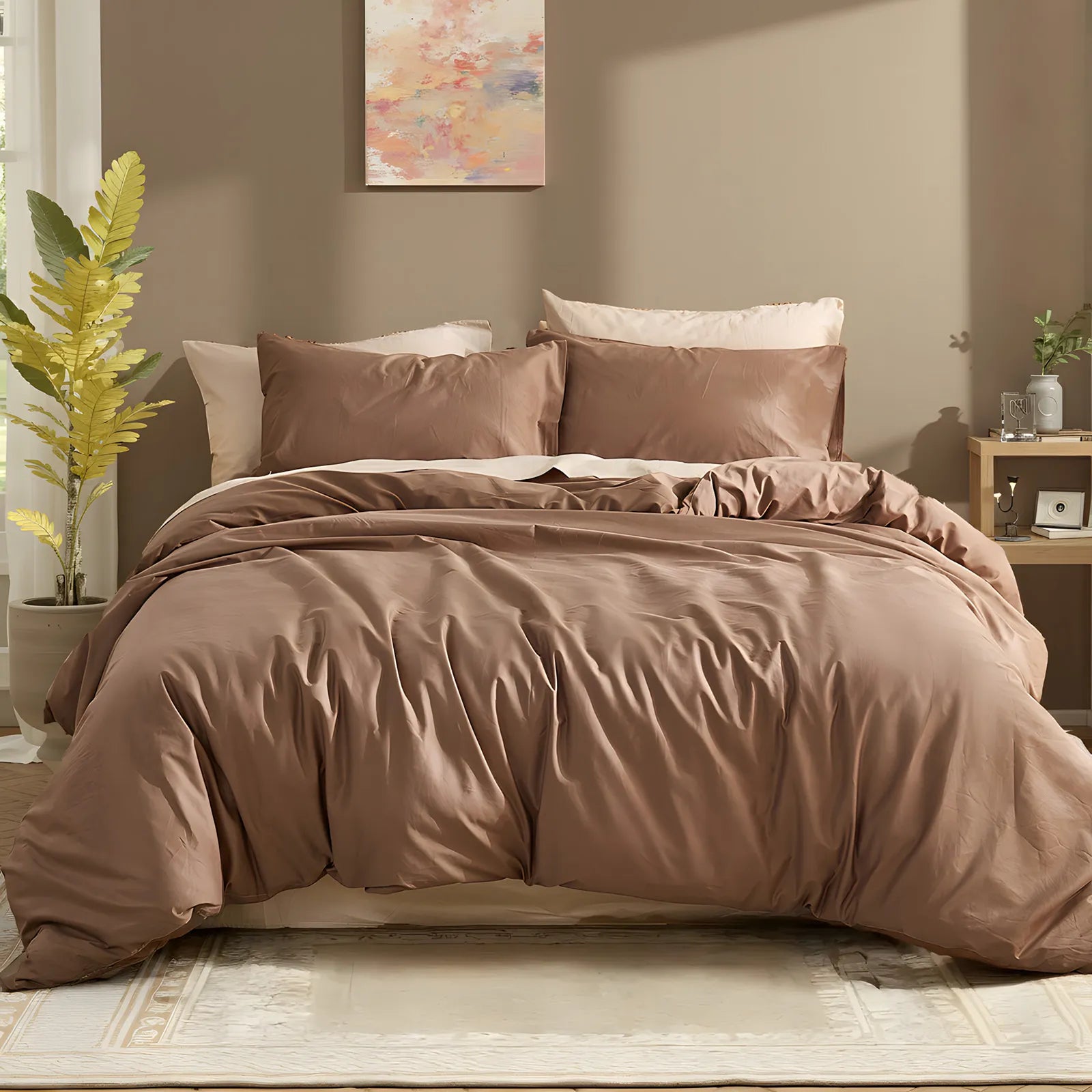 Front view of brown cotton duvet with brown and pink pillows against abstract wall art with green plants on both sides.