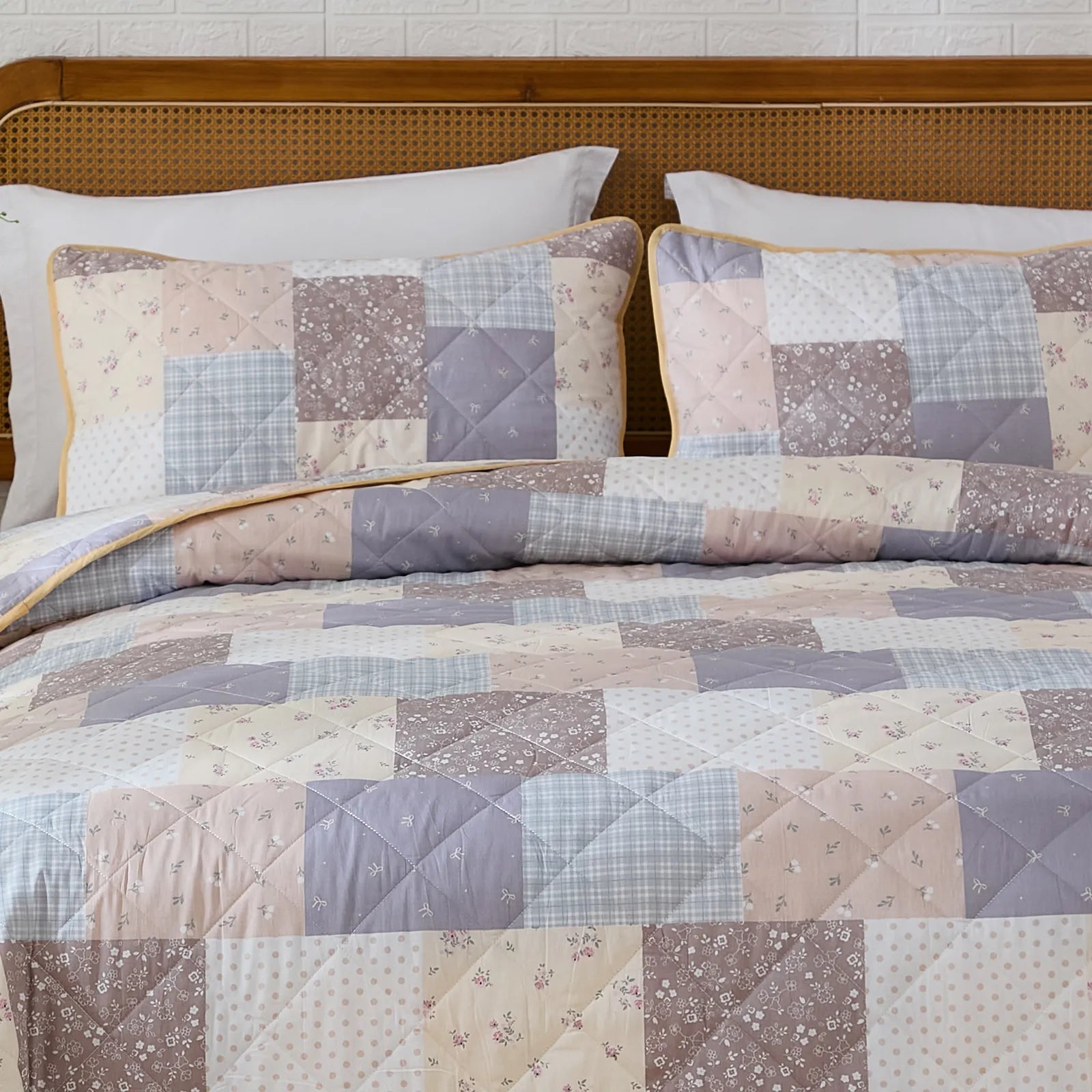 Close-up of the bed corner showing the layered look of the floral quilt set
