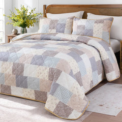 The cottage floral quilt set styled in a cozy bedroom.