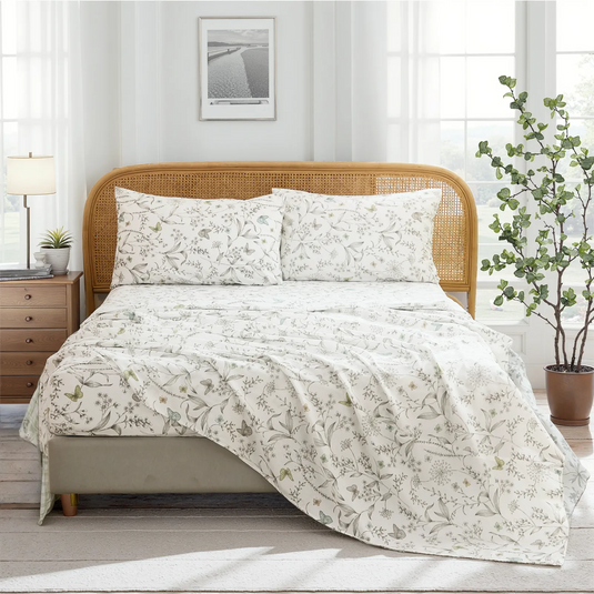 Full room view of cotton botanical sketch floral sheet set on bed with rattan headboard