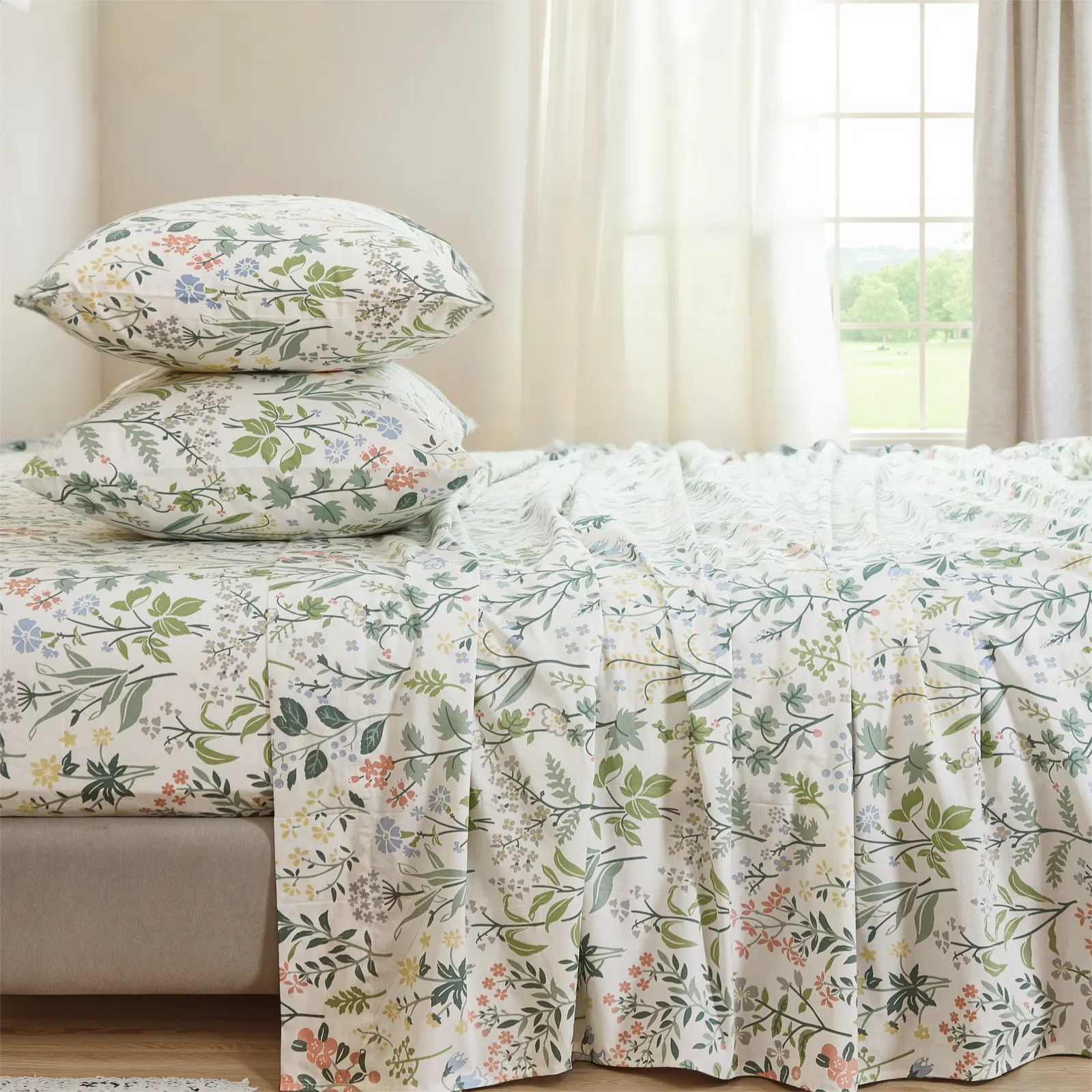 Stacked floral cotton pillows on a fitted sheet, showing bottom drape