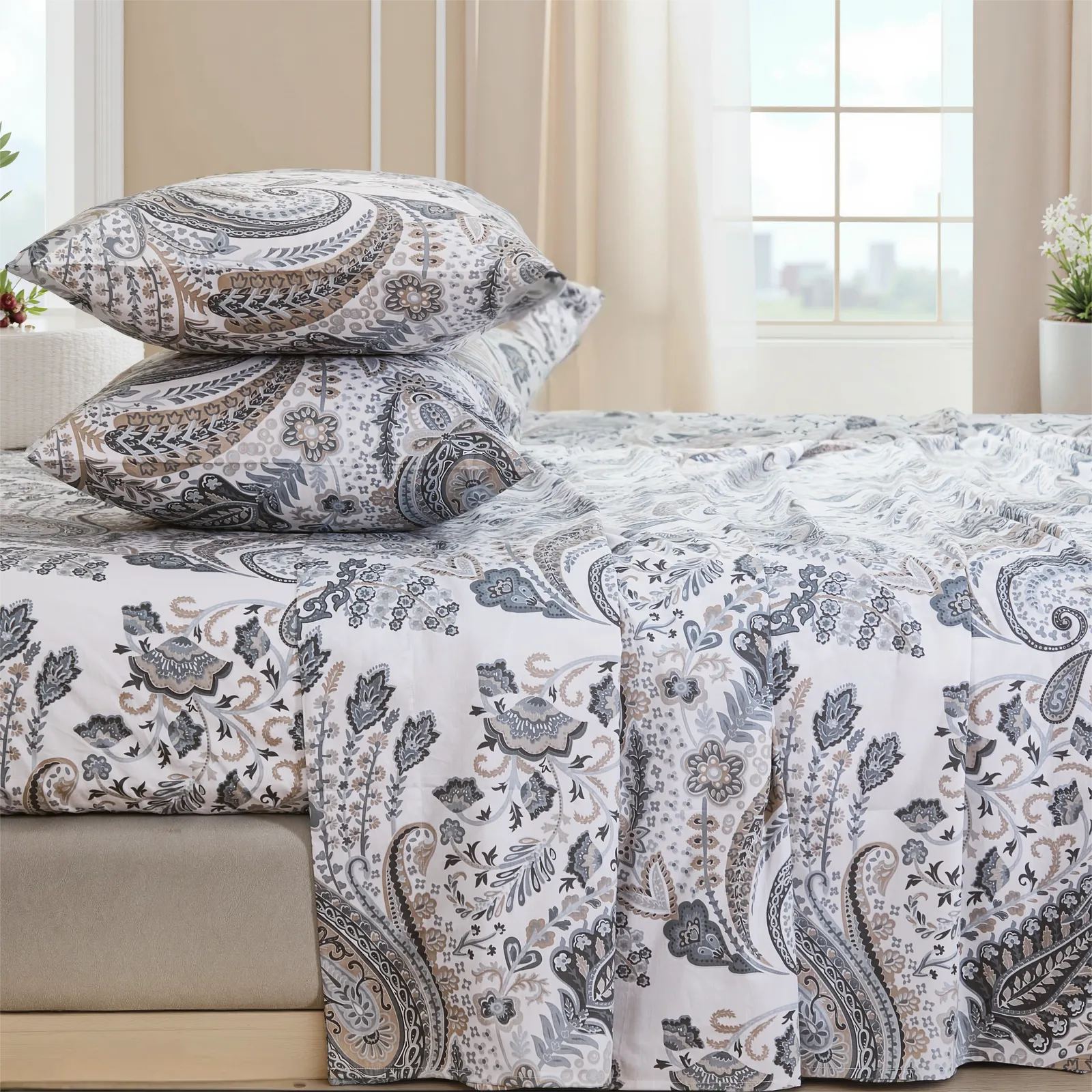 Neutral paisley print cotton bedding set draped on bed with ample natural light