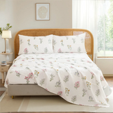 Full view of cotton wildflower floral sheet set on bed with rustic rattan headboard