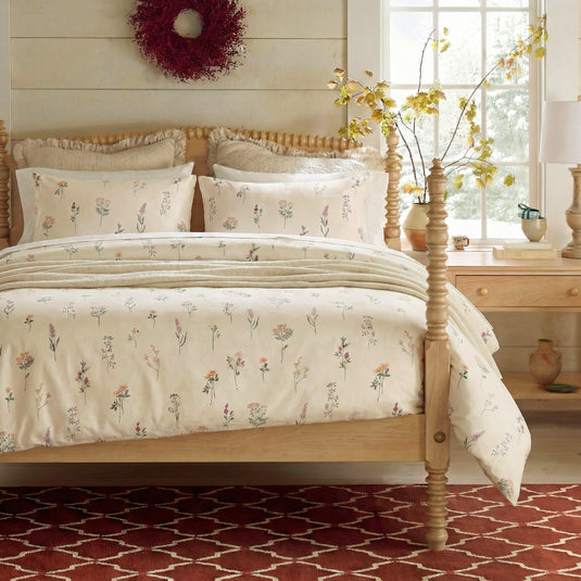 Full view of the cute floral pillowcases styled on a bed with a comforter