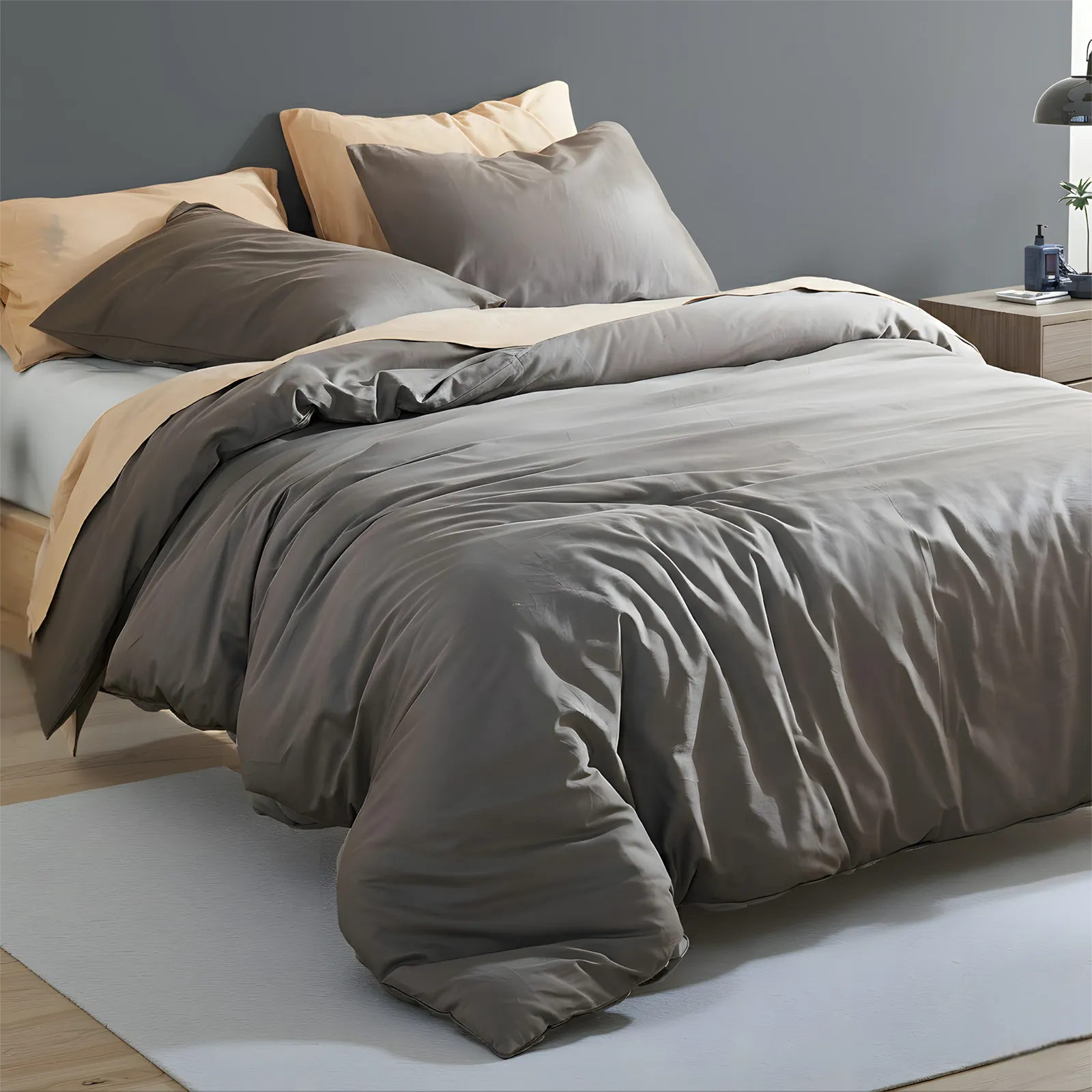 Side view of dark gray duvet with four pillows on bed
