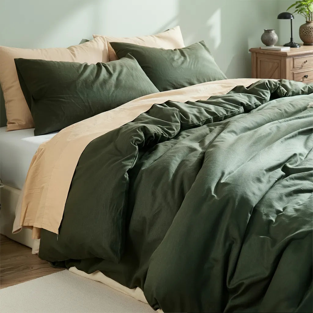 Angled view of dark green duvet in Nordic-style setting with lamp, books and natural light shadows.