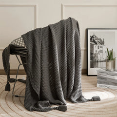 Dark Grey Knitted Throw Blanket on Metal Chair with Book Stack Decor