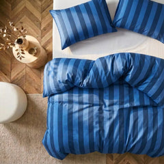 Overhead flat lay of dark blue and deep blue striped duvet and cases