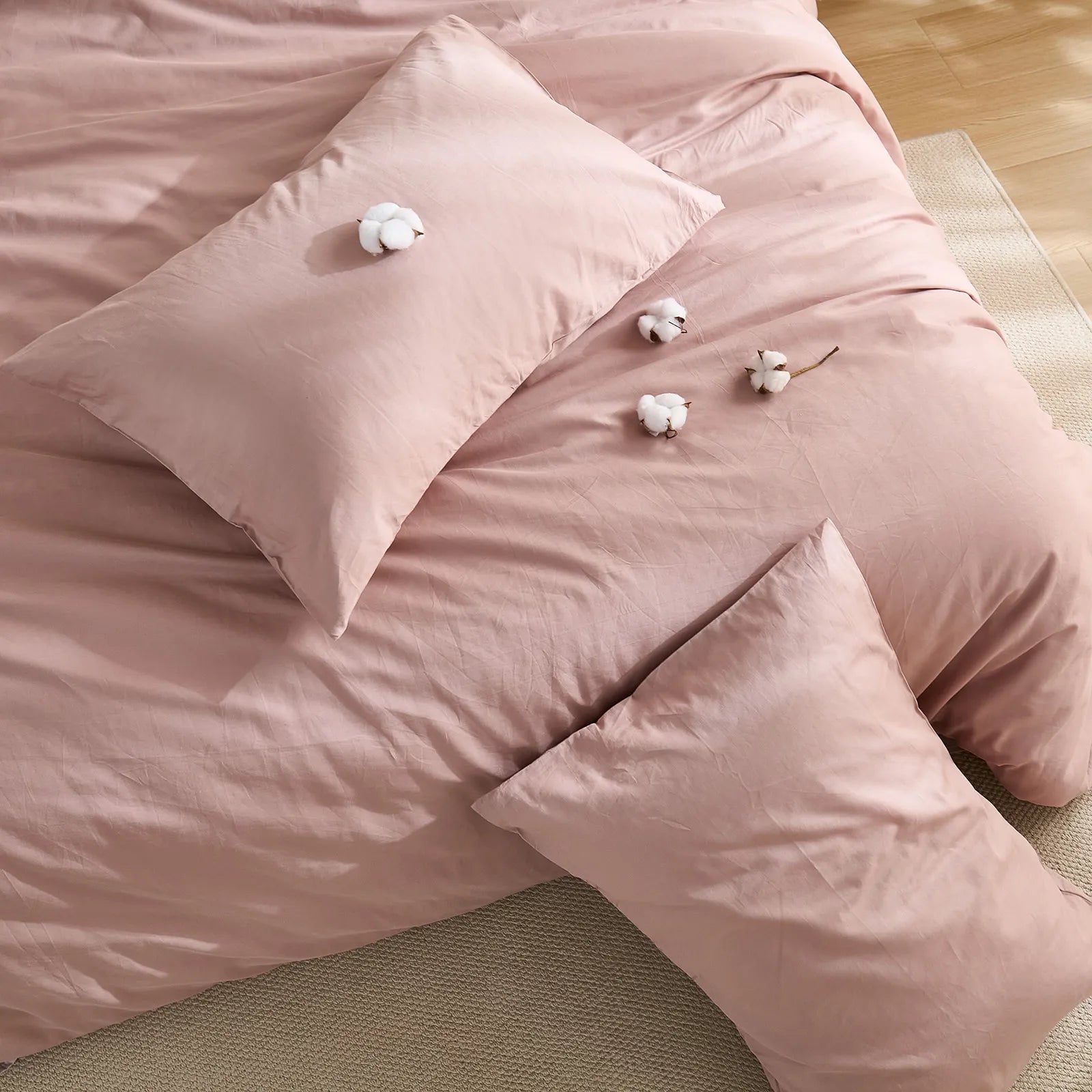 Dusty pink solid duvet full layout with four cotton blooms and two pillows