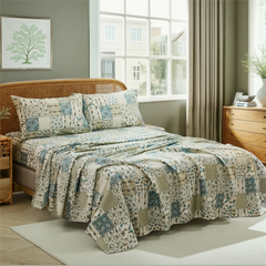 Blue and green floral patchwork cotton sheet set draped on bed in cozy country room