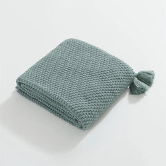 Folded Aqua Knitted Throw Blanket on White Background Showing Tassel
