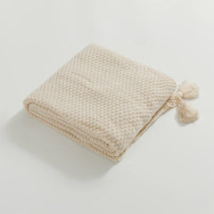 Folded Beige Knitted Throw Blanket Showing Tassel Detail