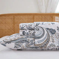 Close up stack of folded cotton neutral paisley fitted sheet and pillowcases studio shot