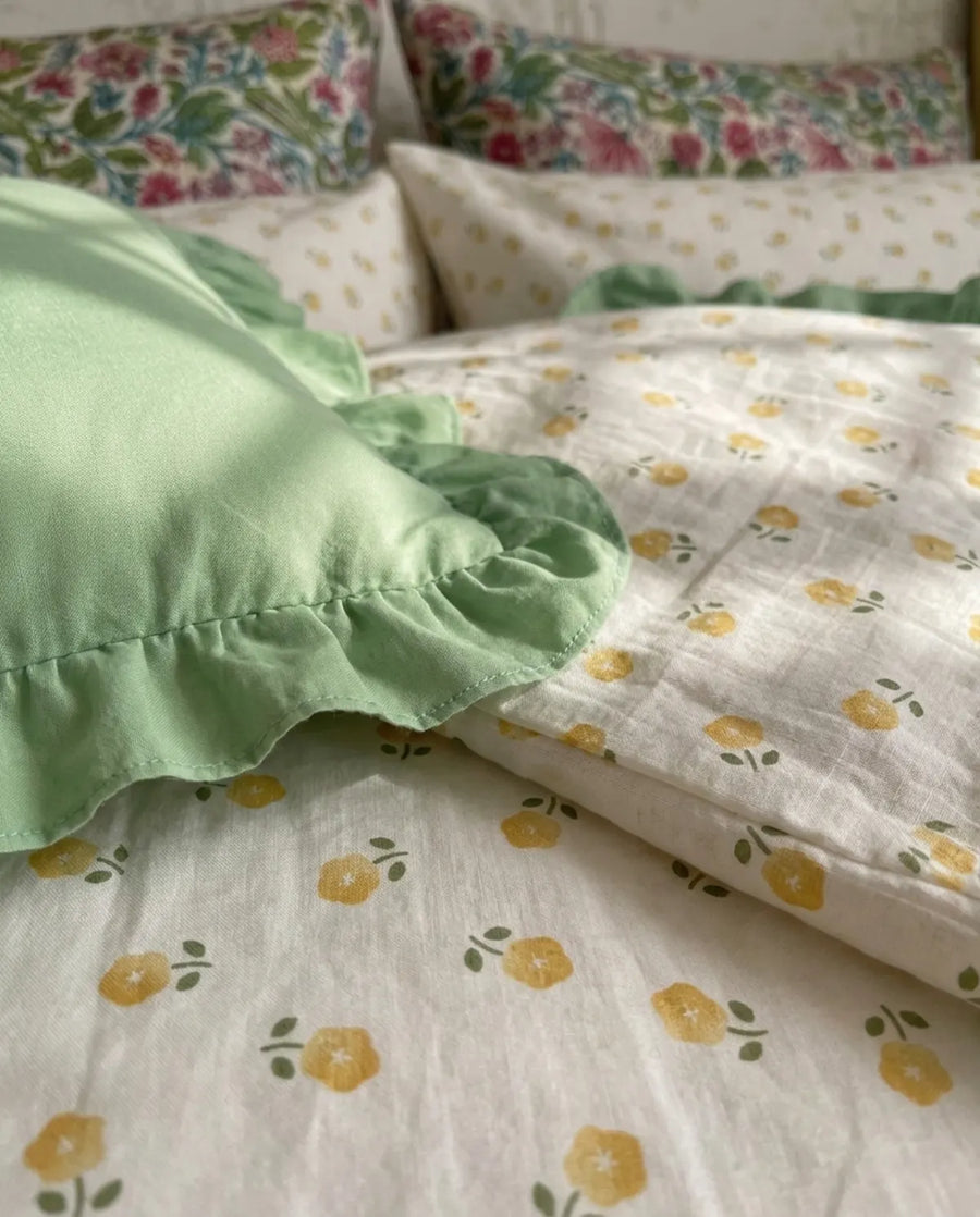 golden ditsy floral duvet cover and sage green ruffle sham detail
