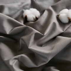 Gray fabric texture detail with two cotton pieces on wrinkled surface