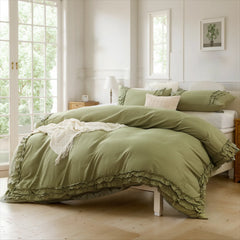 Green cotton double ruffle duvet cover on a white bed frame, with white French doors and a plant print on the wall.