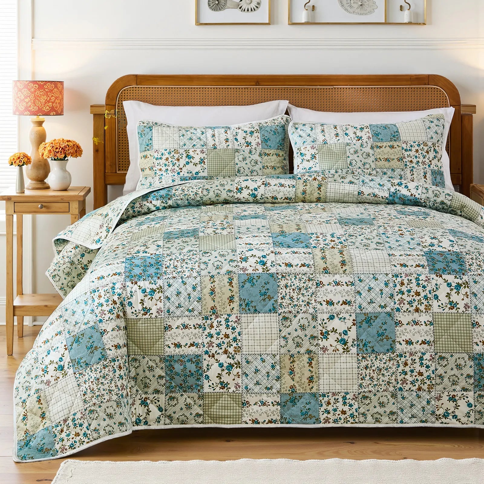 Full view of a bed with a green and blue patchwork quilt set, wood headboard, and matching lamps.