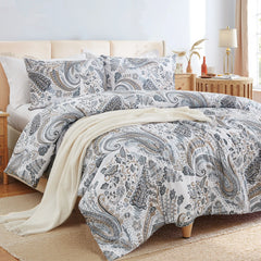 An angled view of the grey paisley comforter set, showing the pillows and decorative items