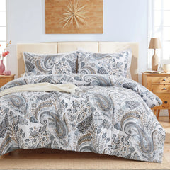 Full view of the grey paisley comforter set styled on a bed in a bright bedroom