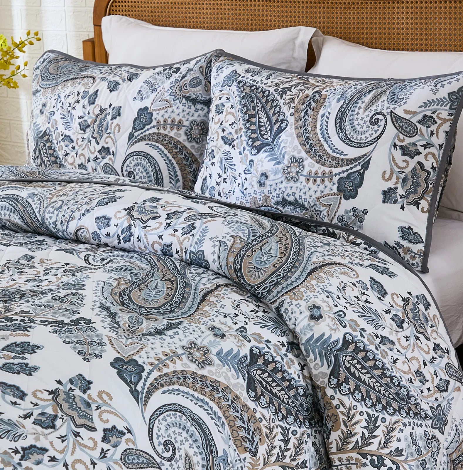 Close-up shot of the intricate grey paisley pattern and stitching on the quilt.