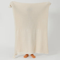 Person Holding Up Beige Knitted Throw Blanket with Tassels Full View