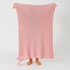 Person Holding Up Pink Knitted Throw Blanket with Tassels