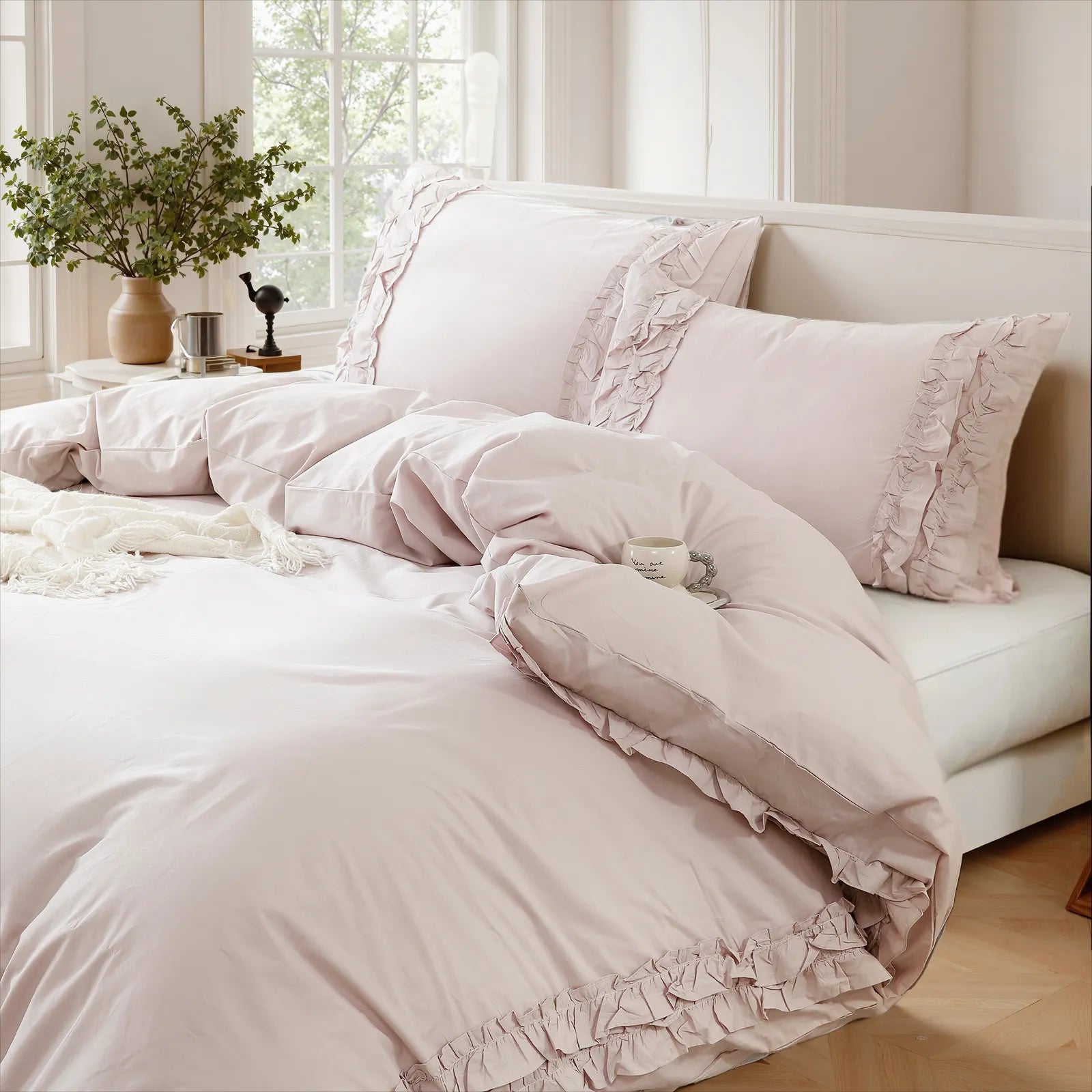 Close-up detail of the lavender cotton double ruffle duvet cover with a white knit throw and decorative items on the windowsill.