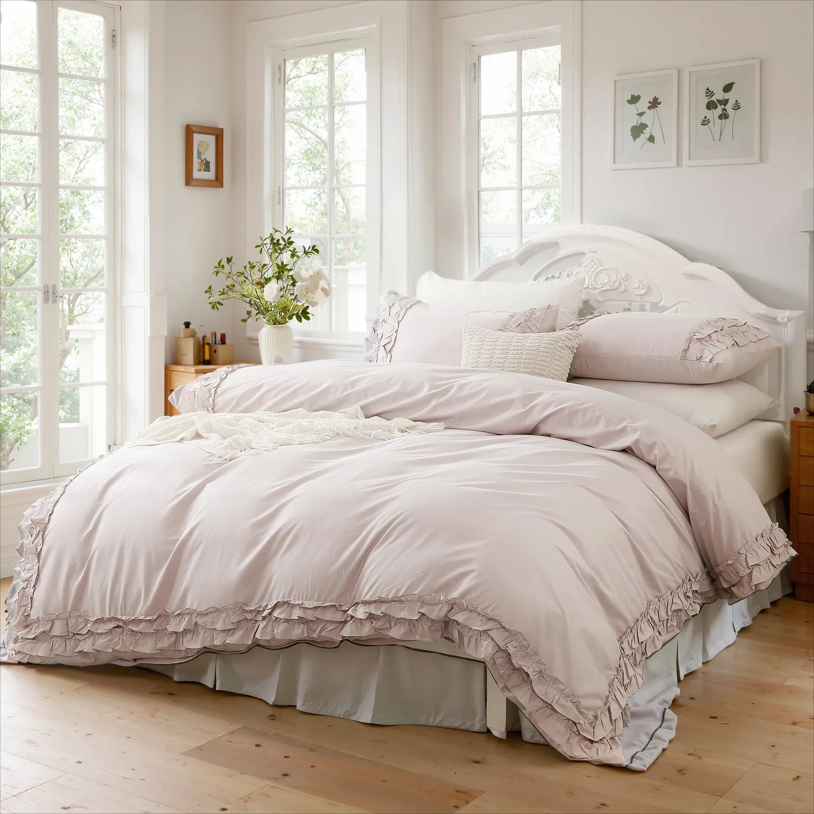 Lavender cotton double ruffle bedding neatly arranged on a white sleigh bed, with botanical prints and a vase on the nightstand.