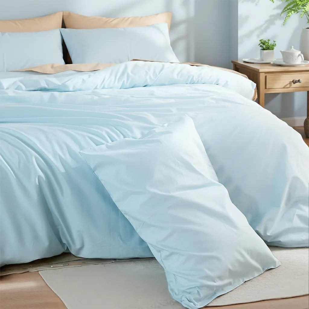 Right-side view of a light blue duvet set with a white teapot and small plants on the nightstand.
