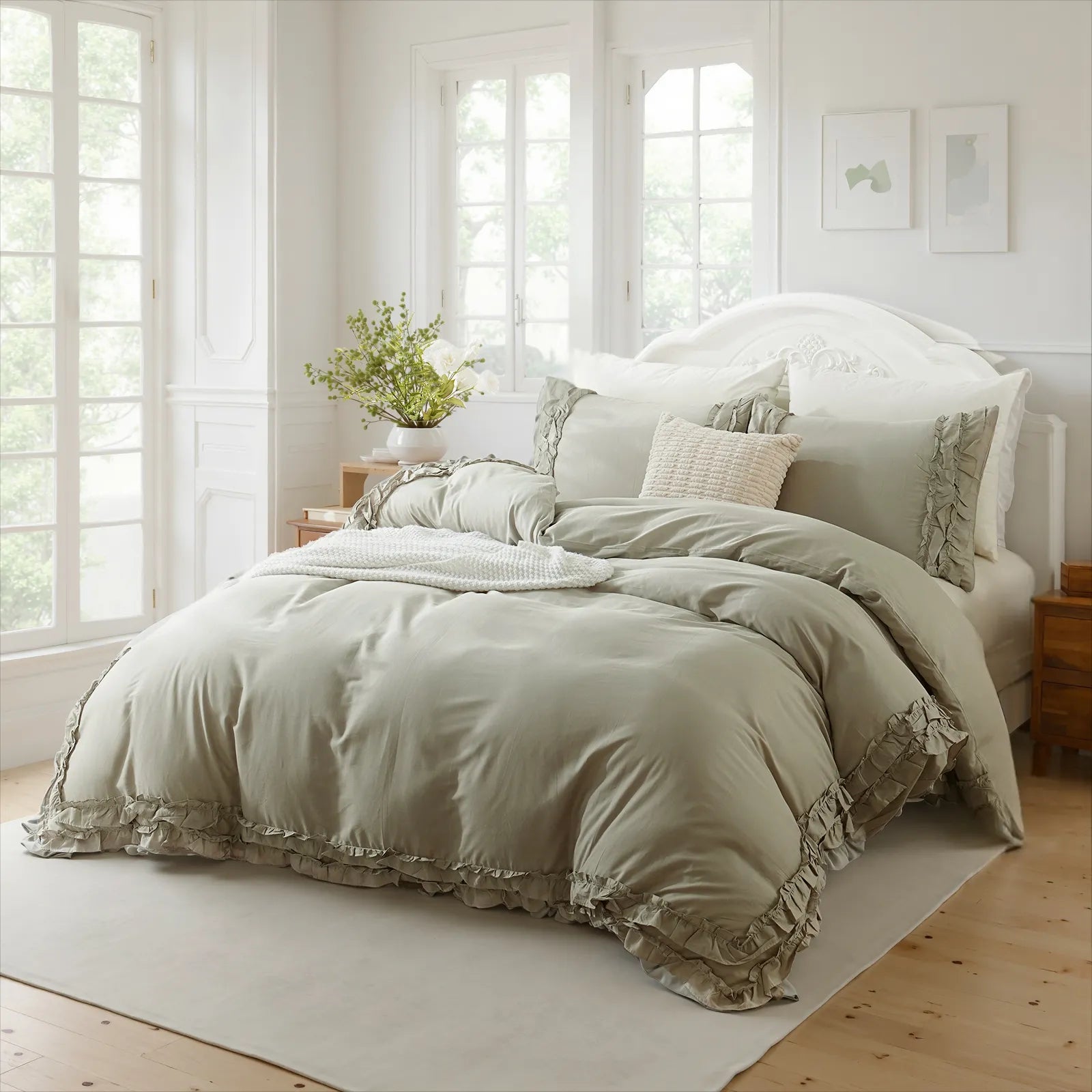 Light gray cotton double ruffle duvet cover on a bed with a white carved headboard, between three large windows.