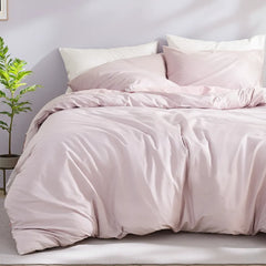 Eye-level view of light purple duvet with white, purple and pink pillows in minimalist bedroom setting.