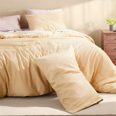 Right side view of light yellow duvet neatly spread on bed with matching pillows.