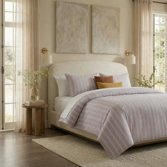 Angled shot of light grey and pink striped duvet cover on bed