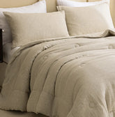 Pair of natural french linen pillowcases styled on a bed with a comforter