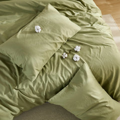 Olive green duvet cover with four cotton clusters and three pillows arrangement